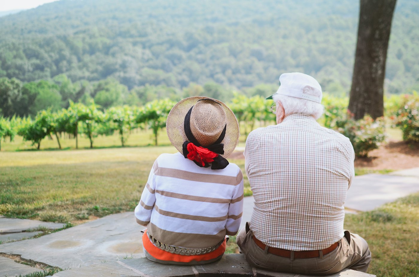 An older couple sitting together outdoors on a sunny day