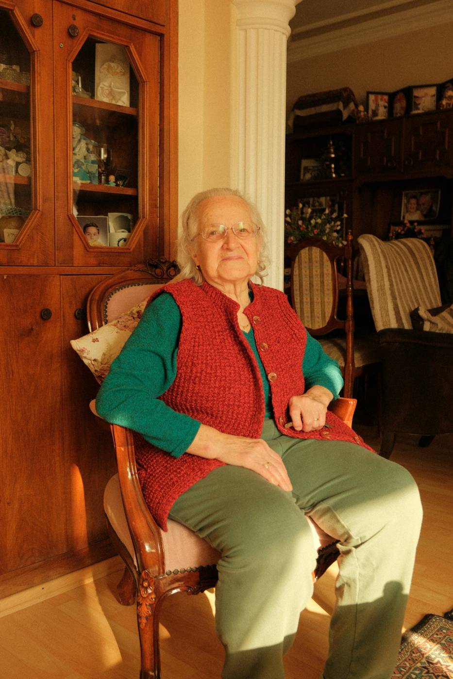An older woman resting in an armchair in her living room